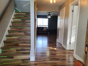 Stairway with ceiling fan and wood finished floors