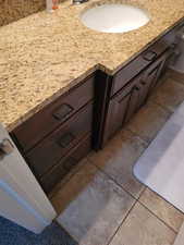 Bathroom with light tile patterned flooring and vanity