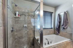 Bathroom featuring a shower stall and a bath
