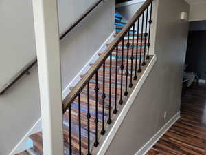 Staircase with baseboards and wood finished floors