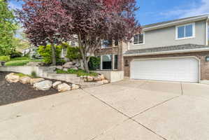Brick and stucco exterior featuring a two-car garage with a paneled door