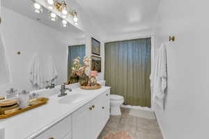Bathroom featuring vanity, light tile patterned floors, and shower / tub combo