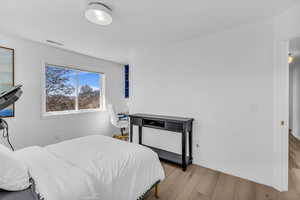 Bedroom with wood finished floors and baseboards