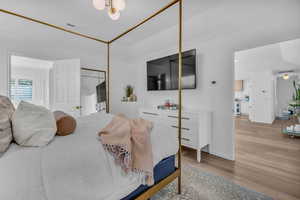 Bedroom featuring light wood-style floors, a closet, and crown molding
