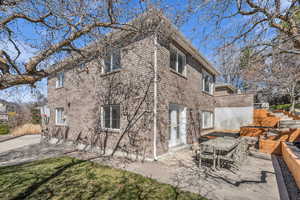 Rear view of property with a patio, outdoor dining area, french doors, and brick siding