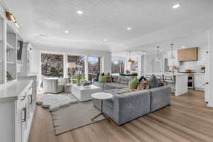 Living area featuring light wood finished floors, recessed lighting, and a textured ceiling