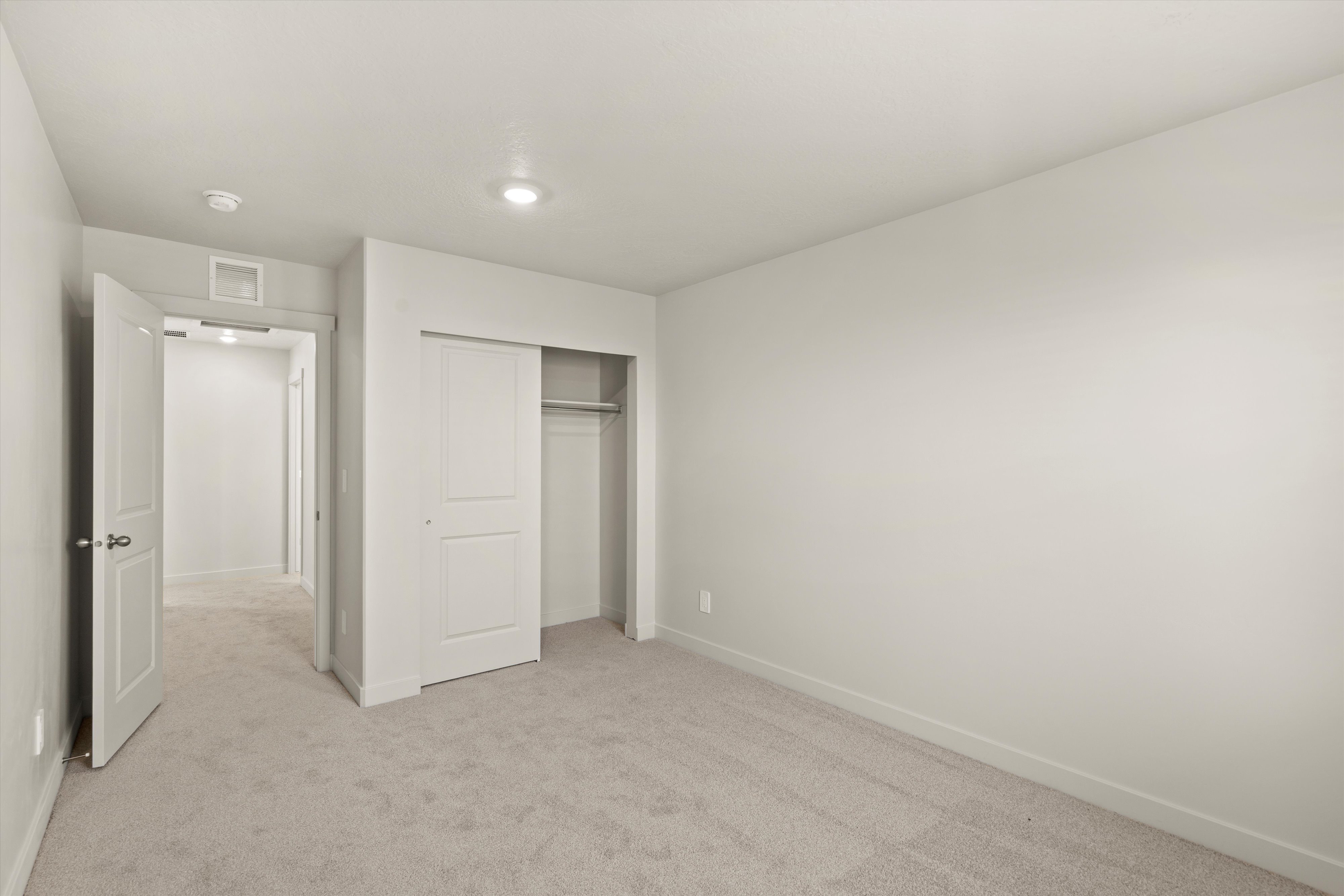 Unfurnished bedroom featuring light colored carpet and a closet
