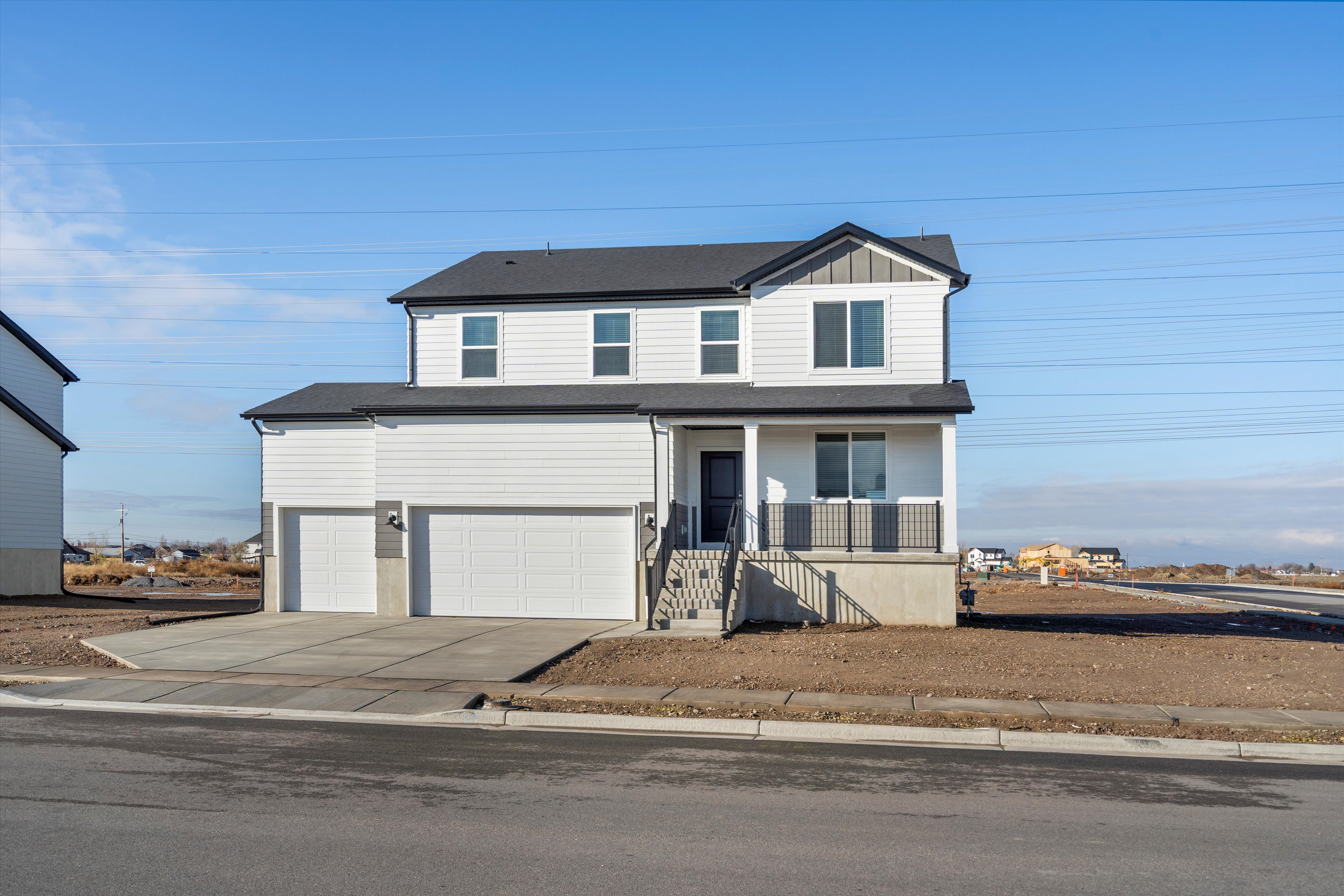 View of front of home with concrete driveway, covered porch, board and batten siding, and an attached garage