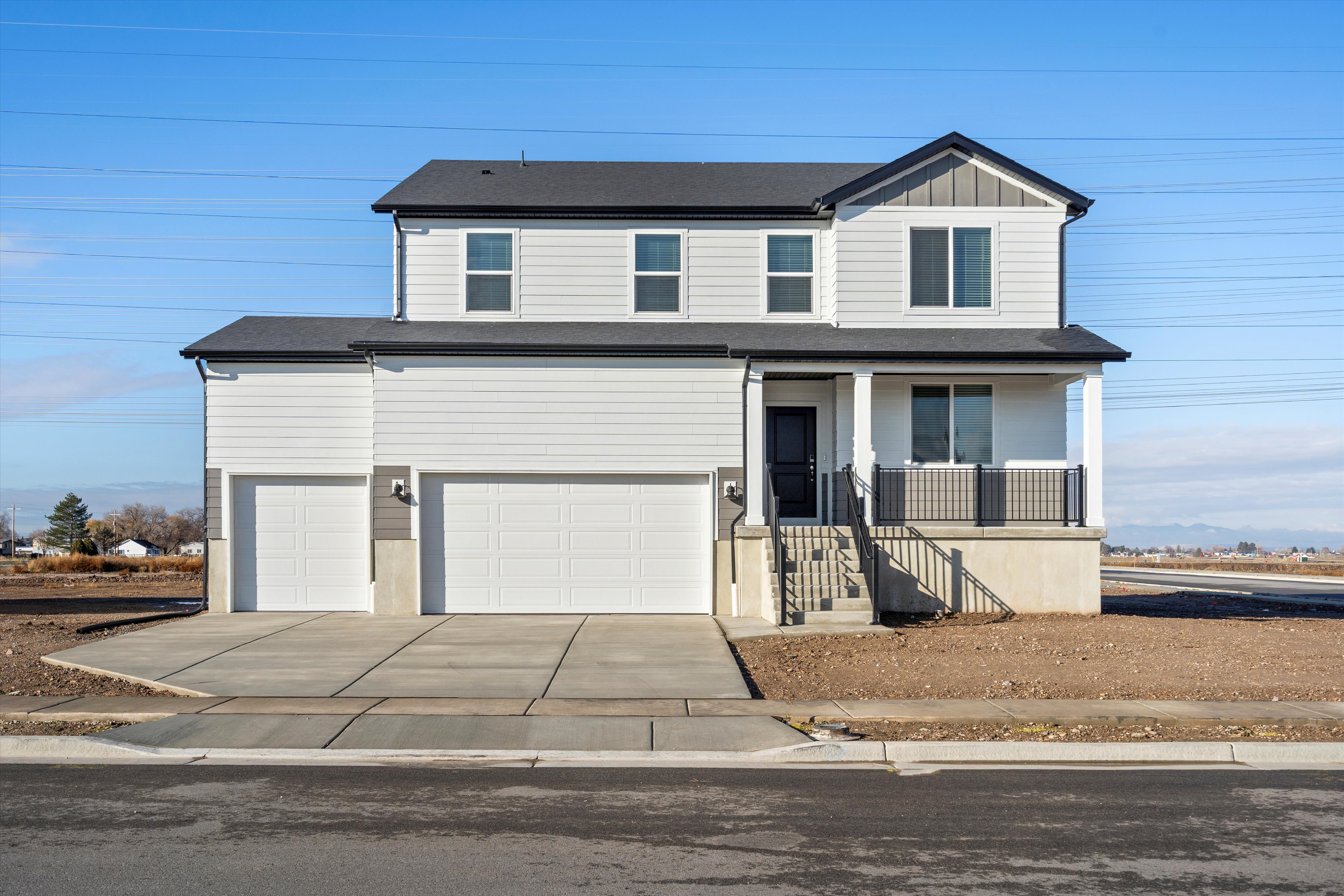View of front facade featuring a porch, concrete driveway, a garage, and board and batten siding