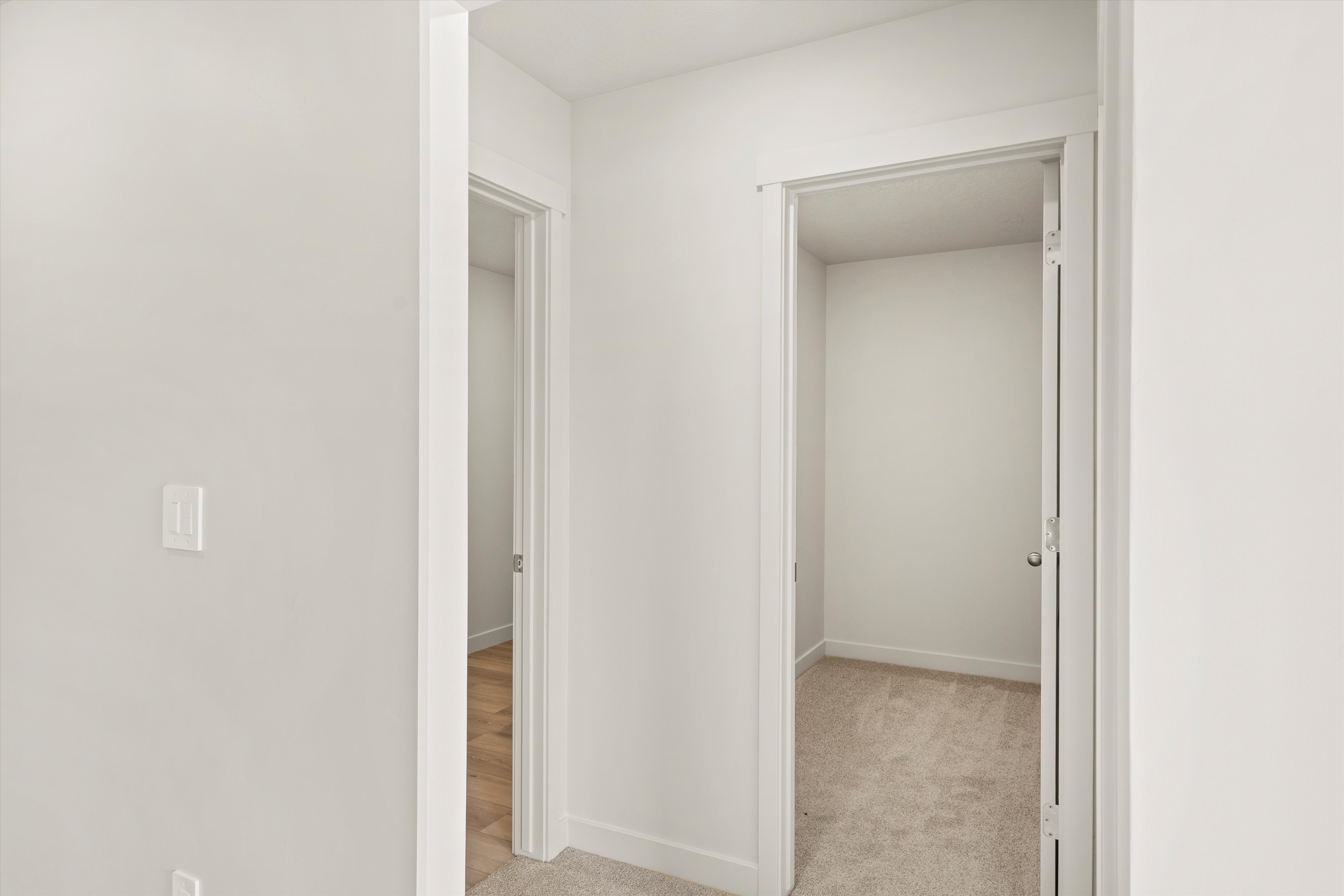 Corridor featuring light carpet and baseboards