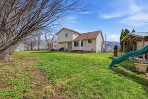 Rear view of house featuring a playground, a patio area, and entry steps
