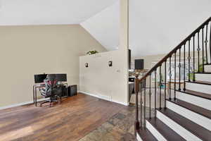Office area featuring wood finished floors and vaulted ceiling