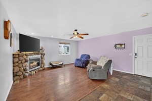 Living area featuring stone finish floors, ceiling fan, a stone fireplace, and recessed lighting