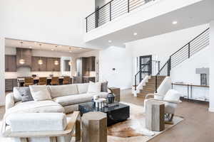 Living area featuring a high ceiling, recessed lighting, and light wood-type flooring