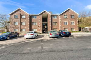 View of apartment building / complex featuring uncovered parking