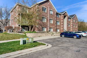 View of apartment building / complex featuring uncovered parking