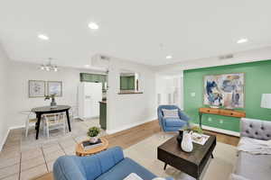 Living area featuring light wood-type flooring and a chandelier