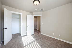 Unfurnished bedroom featuring light colored carpet and a closet
