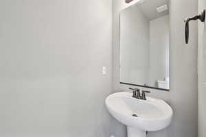 Bathroom featuring a sink and new toilet right off the kitchen