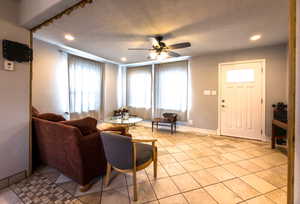 Living room with recessed lighting, a textured ceiling, ceiling fan, and light tile patterned floors