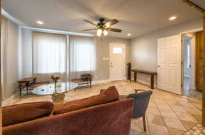 Living area with a ceiling fan, recessed lighting, and light tile patterned floors