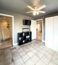 Unfurnished living room featuring light tile patterned flooring and a ceiling fan
