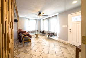 Living area featuring a textured ceiling and ceiling fan