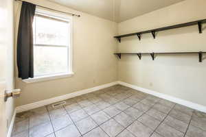 Empty room with light tile patterned floors and baseboards
