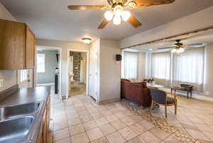 Living area with a ceiling fan and light tile patterned floors