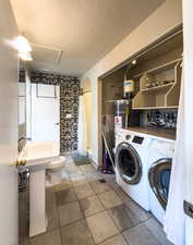 Laundry area featuring washer and dryer and a textured ceiling