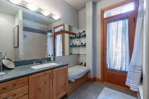 Bathroom with vanity, a shower with curtain, and dark tile patterned floors