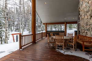 Snow covered deck featuring outdoor dining space