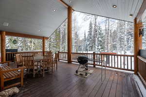 Wooden terrace featuring grilling area and outdoor dining space