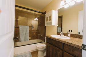 Bathroom featuring vanity and combined bath / shower with glass door