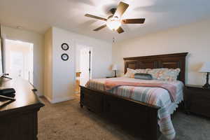 Bedroom featuring dark carpet, ceiling fan, and ensuite bathroom