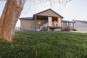 Rear view of house featuring stucco siding and stairs