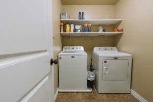 Laundry area featuring washing machine and clothes dryer and baseboards