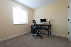Carpeted office space featuring baseboards