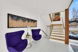 Sitting room featuring stairs and light tile patterned floors