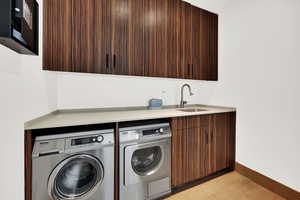 Laundry area featuring cabinet space, separate washer and dryer, and light tile patterned floors