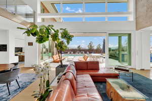 Sunken living room featuring a high ceiling, wood finished floors, and healthy amount of natural light