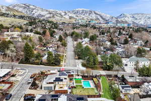 Aerial perspective of suburban area with a mountain backdrop and a pool