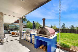 Fenced backyard with an outdoor kitchen / dining area and a patio area