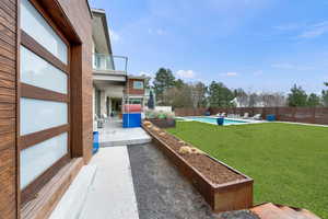 Fenced backyard with a patio and a balcony