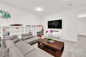 Living area with light carpet and baseboards