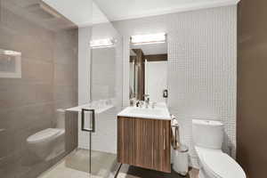 Full bath featuring vanity, a shower stall, light tile patterned floors, and tile walls