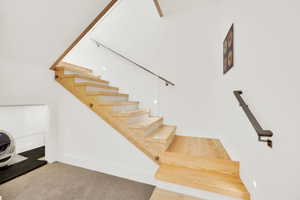 Staircase with carpet and baseboards