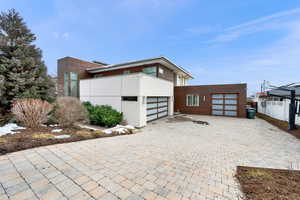View of front facade featuring decorative driveway and stucco siding