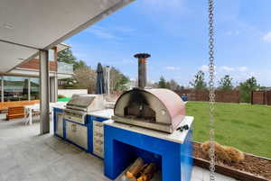 Fenced backyard with an outdoor kitchen / dining area and a patio