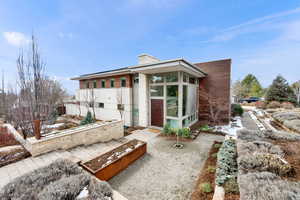 View of front of home with a chimney and a sunroom